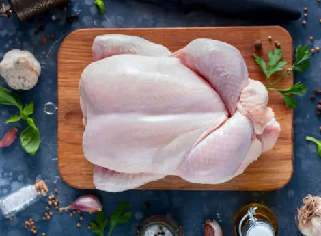 Karkas ayam segar yang ditempatkan diatas sebuah talenan kayu